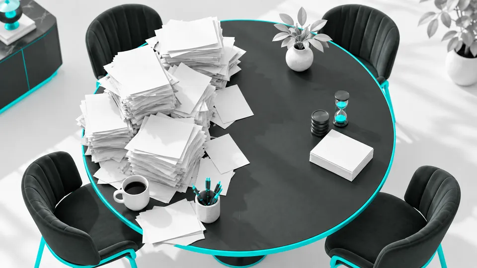 Mesa de reunião com pilhas de tarefas, fichas e ampulheta representando trabalho repetitivo.